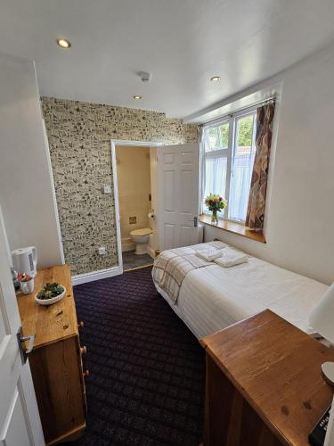 a bedroom with a large bed and a bathroom at The Ship Inn in Oundle