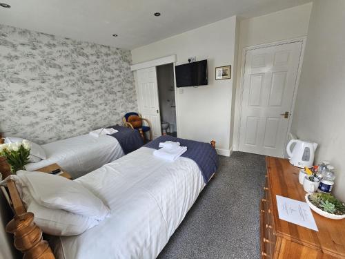 a hotel room with two beds and a table at The Ship Inn in Oundle