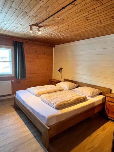 a bedroom with two beds and a wooden wall at Apartments Pihapperhof in Mittersill