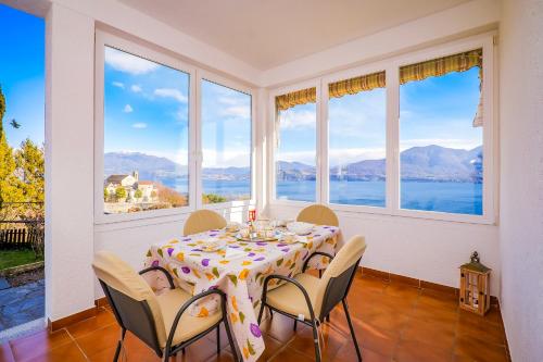 een eetkamer met een tafel en uitzicht op het water bij Appartamento Valentina in Oggebio