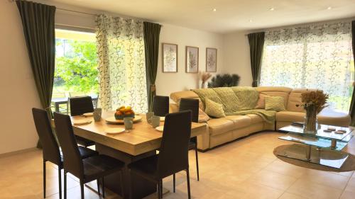 un salon avec une table et un canapé dans l'établissement La Pause Limousine, Garden, Wi-Fi, Near Limoges, Golf, Bowling, à Feytiat