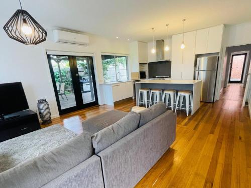 a living room with a couch and a kitchen at Spacious 4bdr family home away from home in Newport