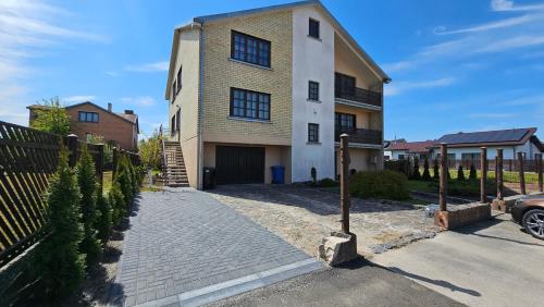 a large house with a driveway in front of it at Guest house Sunrise in Šiauliai