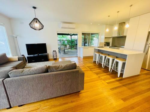 a living room with a couch and a kitchen at Spacious 4bdr family home away from home in Newport