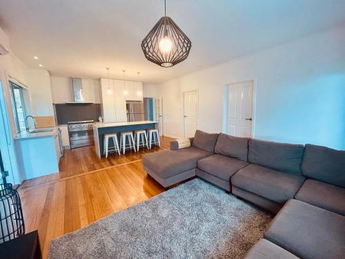 a living room with a couch and a kitchen at Spacious 4bdr family home away from home in Newport