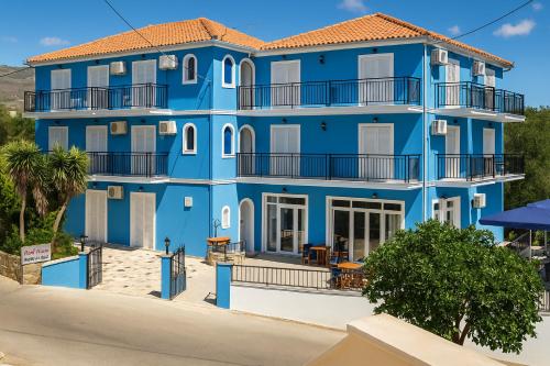 a blue building on the beach in front of a building at Blue Lake Holiday Homes - Keri Summer Escape in Keri