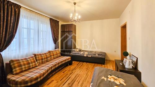 a living room with a couch and a bed at Guest house Sunrise in Šiauliai