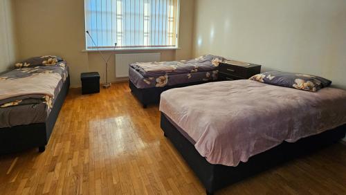 a room with three beds and a window at Guest house Sunrise in Šiauliai