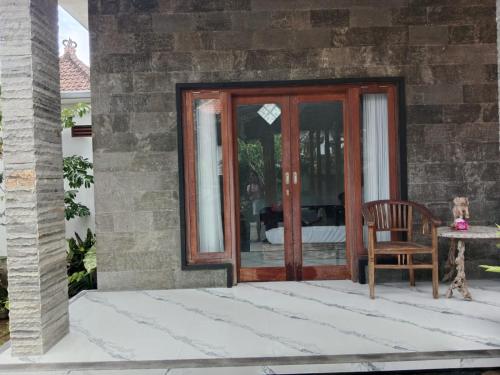 a wooden door with a chair on a patio at Niraka Home in Bebandem