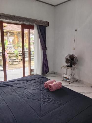 a bedroom with a bed with a black blanket at Niraka Home in Bebandem