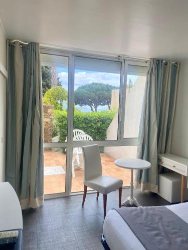 une chambre avec un lit et une fenêtre avec vue dans l'établissement Les Alcyons, au Lavandou