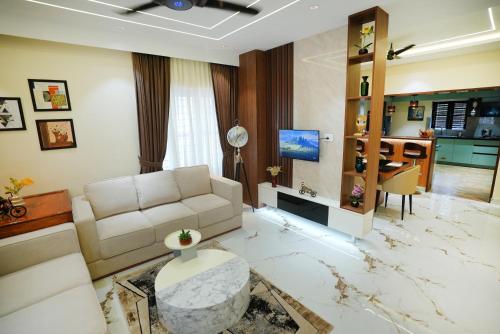 a living room with a couch and a table at Zoe Villa in Trivandrum