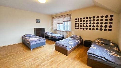 a room with three beds and a table at Guest house Sunrise in Šiauliai
