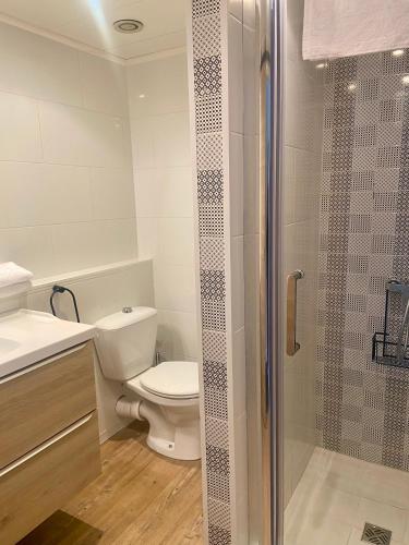 une salle de bain avec toilettes et douche en verre dans l'établissement Les Alcyons, au Lavandou