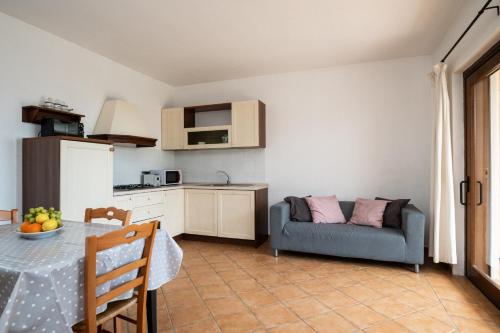 a kitchen and living room with a table and a couch at Bellosguardo 3, 8 - Klodge in Olbia