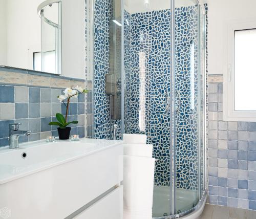 オルビアにあるVilletta Bianca - Klodgeの青いタイルの浴槽とシャワー付きのバスルーム