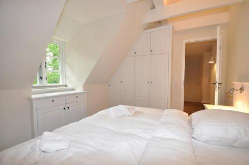 a large white bed in a room with a window at Doppelhaushälfte SPO-Stern in Böhl