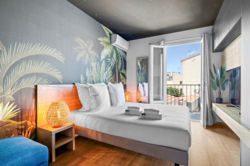 une chambre avec un grand lit blanc et une fenêtre dans l'établissement Beautiful Modern and Design Accommodation, Old Antibes, à Antibes