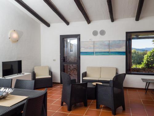 un salon avec des chaises, une table et une télévision dans l'établissement Caletta Nest 10 - Klodge, à Porto Rotondo
