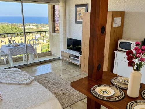 d'un salon avec une table et un balcon. dans l'établissement Studio 1 pièce 3 couchages MARINE DE SANT AMBROGGIO, à Lumio