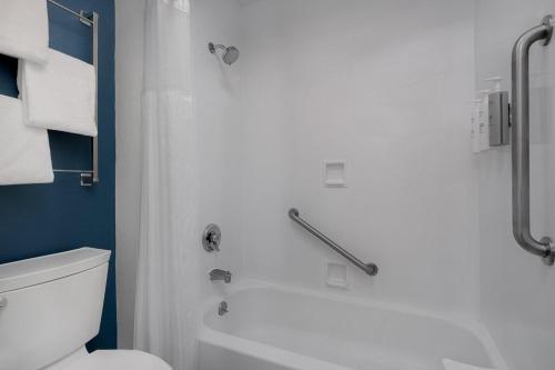 a bathroom with a white toilet and a shower at Spark by Hilton Spring Lake Fayetteville in Spring Lake