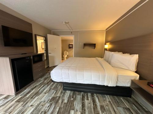 a hotel room with a bed and a flat screen tv at Whalers Inn and Suites in New Bedford