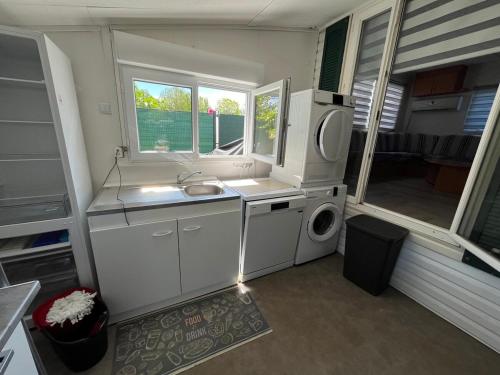 une petite cuisine avec un évier et une machine à laver dans l'établissement Chalet tout confort 6 personnes proche des plages - V0850, à Vias