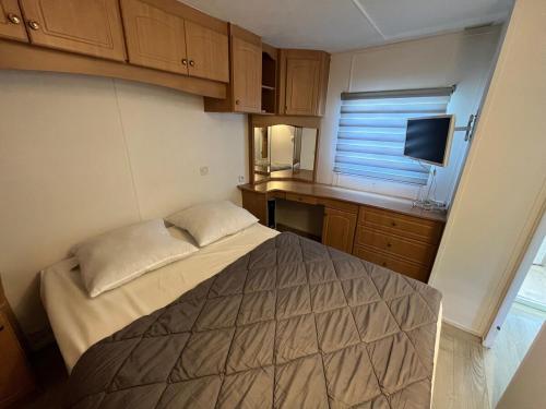 une petite chambre avec un lit et un bureau dans l'établissement Chalet tout confort 6 personnes proche des plages - V0850, à Vias