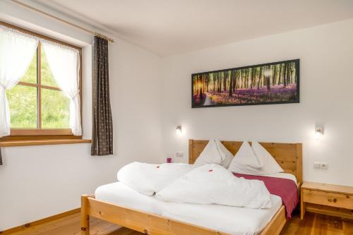 a bedroom with a bed with white sheets at Tratterhof Apartments in Vallarga