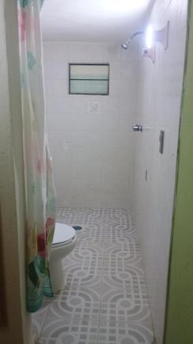 a bathroom with a toilet with a shower curtain at Chantli Ilamatl casa de la abuela in Teotihuacán