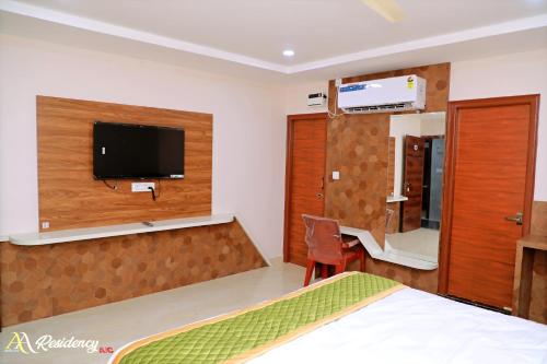 a bedroom with a bed and a tv on a wall at AA Residency in Tirupati