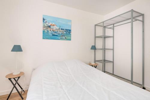 a white bedroom with a bed and a picture on the wall at Maison Dune et Forêt à 100m de la mer in Saint-Michel-Chef-Chef