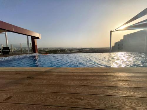 a swimming pool on the roof of a building at Carnelian Muscat - Airport Hotel in Muscat