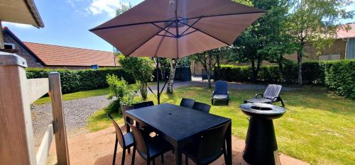 a table and chairs with an umbrella in a yard at La Grange in Verlincthun