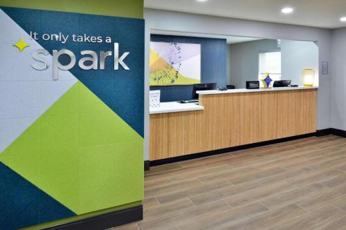 an office cubicle with a sign that reads it only takes a spark at Spark by Hilton Spring Lake Fayetteville in Spring Lake