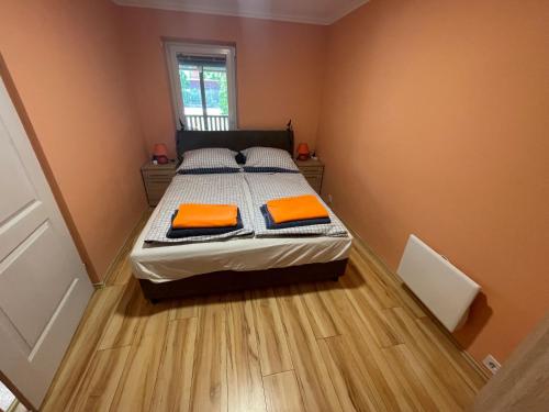 a bedroom with a bed with orange pillows on it at Veronica nyaralóház in Zamárdi