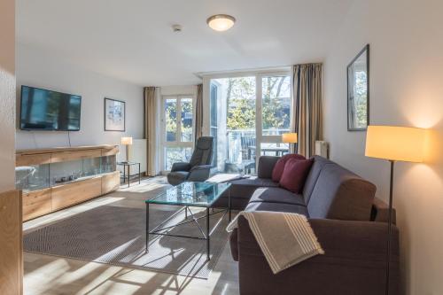 Una sala de estar con un sofá y un televisor. en Ostseeanker - stilvolles Apartment in Strandnähe, en Zingst