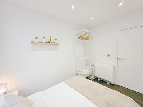 a white bedroom with a bed and a bathroom at Cosy 1 Bed Home, City Centre, Long & Short Stays in Brighton & Hove