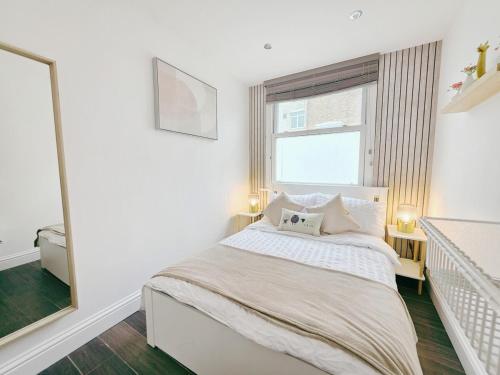 a white bedroom with a bed and a window at Cosy 1 Bed Home, City Centre, Long & Short Stays in Brighton & Hove