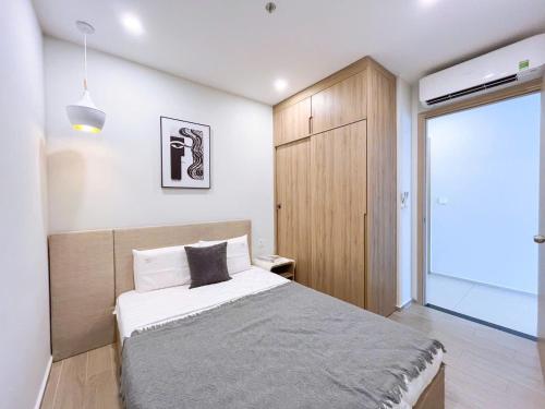 a small bedroom with a bed and a large window at The Song Boutique Apartment in Vung Tau