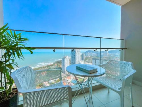 a table and chairs on a balcony with a view of the ocean at The Song Boutique Apartment in Vung Tau