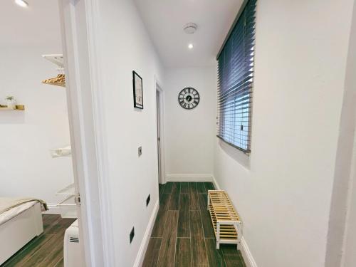 a hallway with a staircase and a clock on the wall at Cosy 1 Bed Home, City Centre, Long & Short Stays in Brighton & Hove