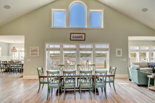 a dining room with a table and chairs at Sounds Beachy in North Topsail Beach