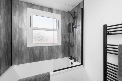 a bathroom with a bath tub and a window at 4BR 2Bathroom in Central Location with Free Parking in Montrose