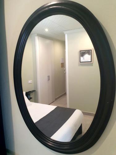 a mirror in a room with a bed in it at Hostal Mi Campaña in Denia