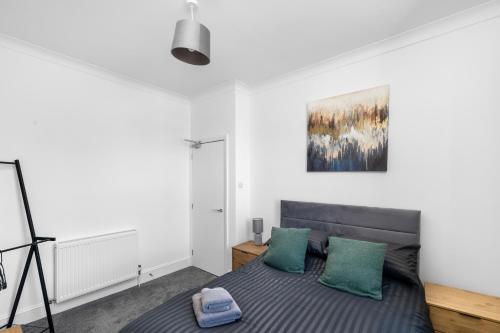 a bedroom with a bed with two green pillows at 4BR 2Bathroom in Central Location with Free Parking in Montrose