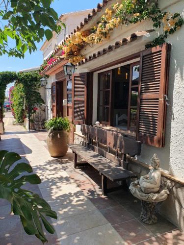 a bench in front of a building with flowers at Hostal Mi Campaña in Denia