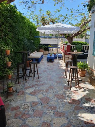 a patio with tables and chairs and an umbrella at Hostal Mi Campaña in Denia