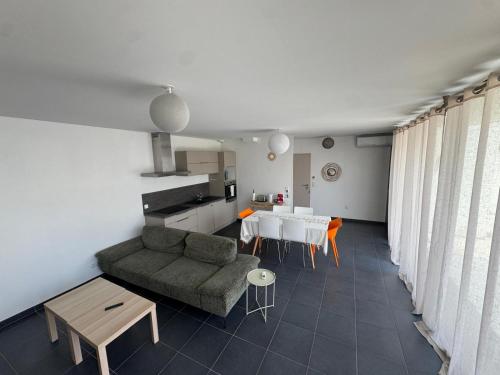 un salon avec un canapé et une table dans l'établissement Sea Road Perpignan, à Perpignan