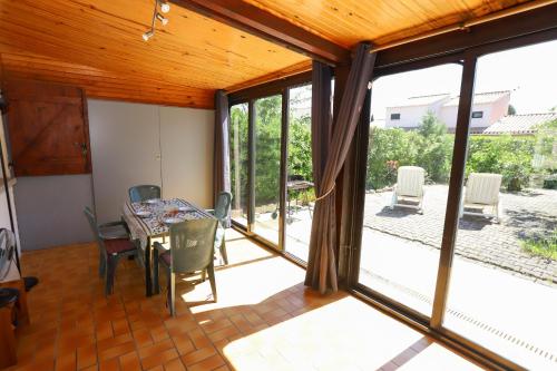 d'une salle à manger avec une table, des chaises et des portes coulissantes en verre. dans l'établissement St Cyprien Maison 4p avec grande terrasse et jardin clos, à Saint-Cyprien